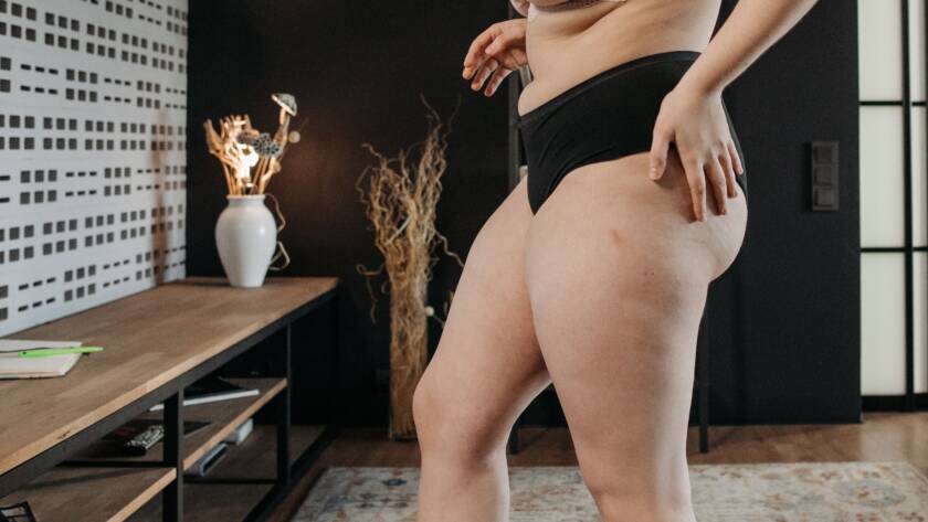 Vrouw in ondergoed die op de weegschaal gaat staan.